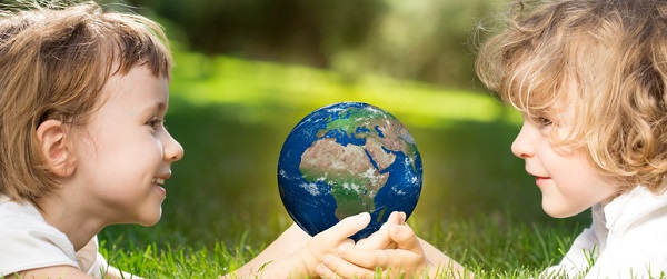 Children`s holding world in hands against green spring background. Earth day concept. Elements of this image furnished by NASA